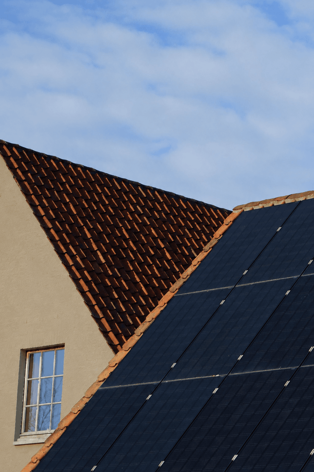 Toiture en tuiles et panneaux photovoltaïques sur une habitation